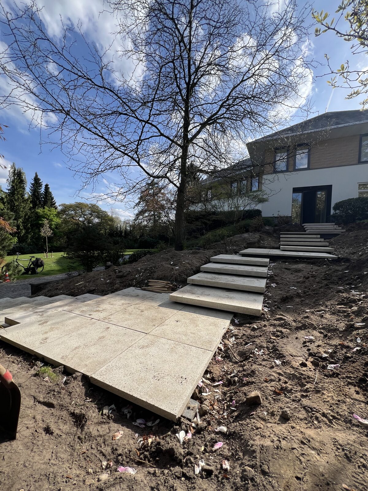 Traptreden en platen van Schellevis in een tuin op afschot