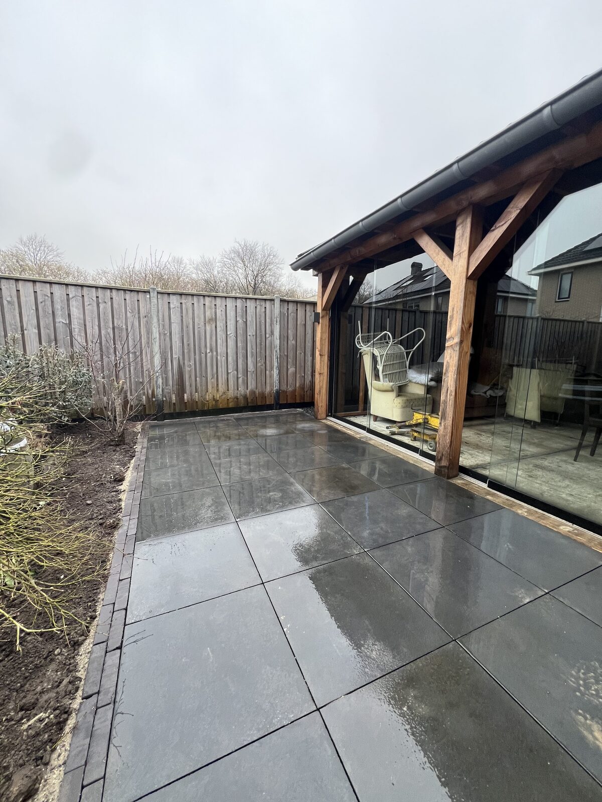 Houten veranda met glazen schuifwand en keramisch terras
