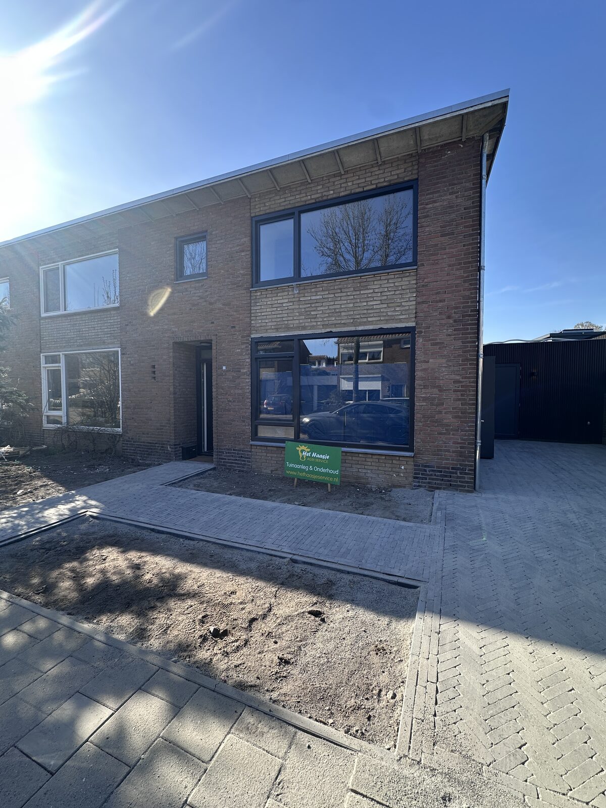 Voor- en zijtuin bestraat, met pad naar de berging